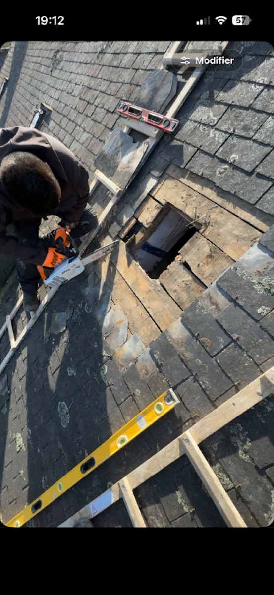 Pose d'un Velux en cours sur une toiture en ardoise